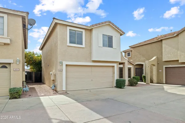 a view of a white house with a yard and plants