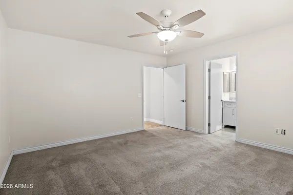 an empty room with a ceiling fan and a window