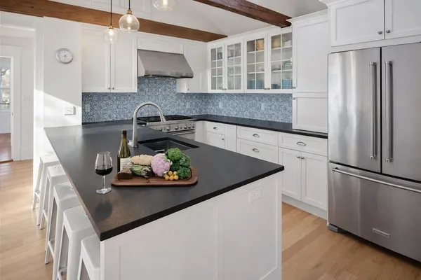 a kitchen with stainless steel appliances granite countertop a sink a refrigerator and a stove