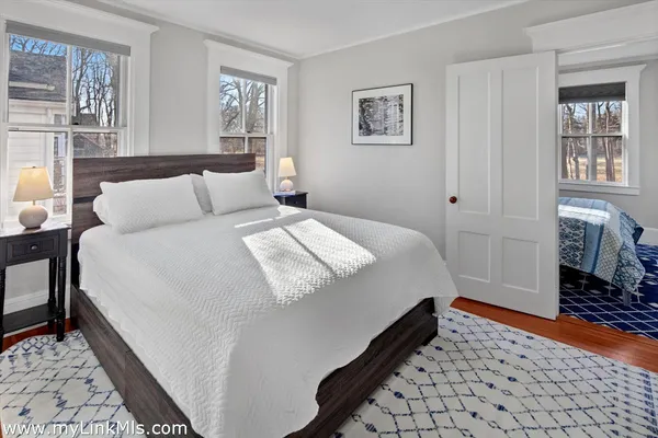 a bedroom with a bed and windows