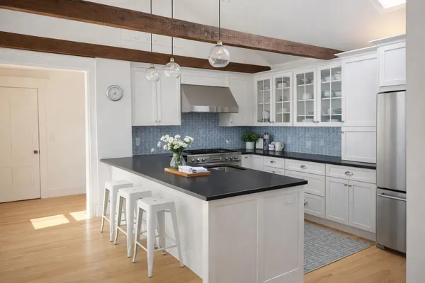 a kitchen with stainless steel appliances granite countertop a sink a stove and a refrigerator