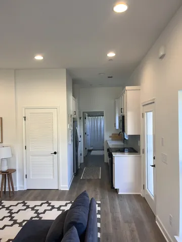 a living room with stainless steel appliances kitchen island granite countertop furniture and a refrigerator