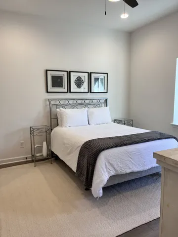 a bedroom with a bed and painting on the wall