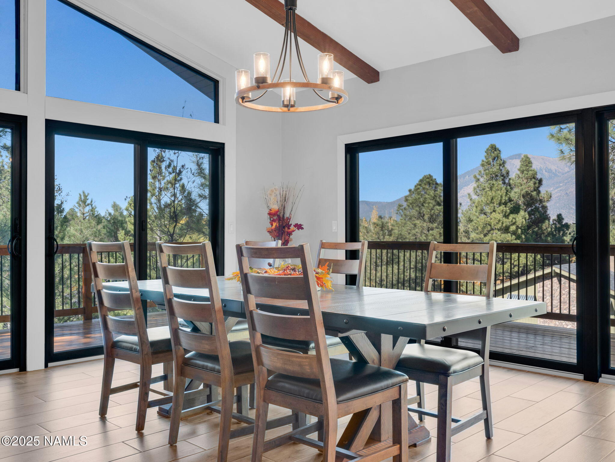 2201 North Fox Hill Road Flagstaff, AZ 86004 - Photo 2 of 38 a dining room with furniture a chandelier and a floor to ceiling window