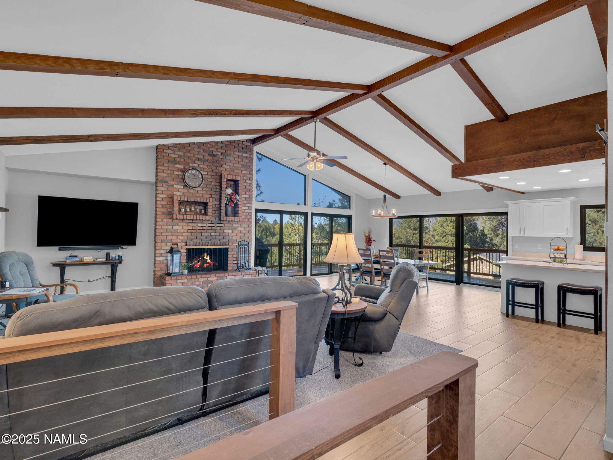 2201 North Fox Hill Road Flagstaff, AZ 86004 - Photo 10 of 38 a living room with furniture a flat screen tv and a floor to ceiling window
