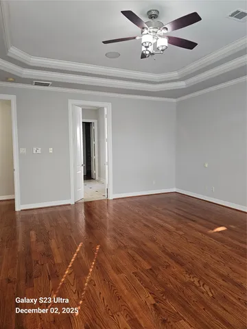 a view of an empty room with wooden floor