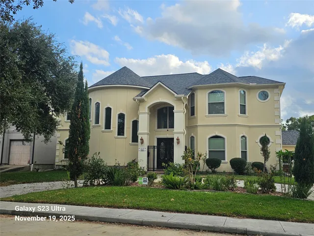 a view of a white house with a yard and plants