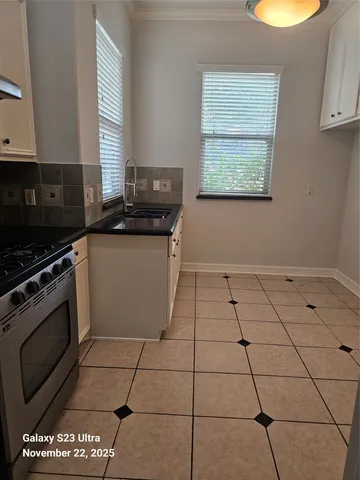a kitchen with granite countertop a stove a sink and a microwave