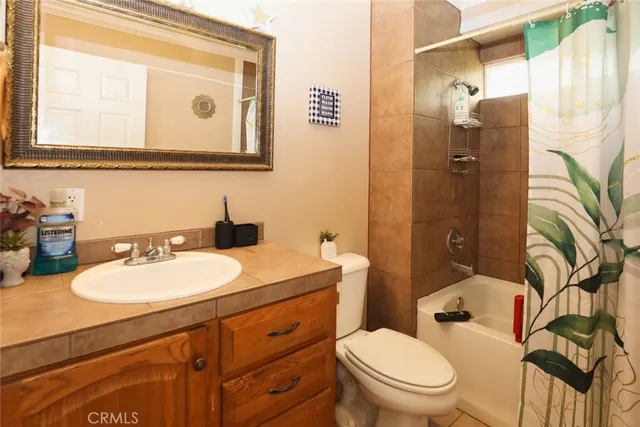 a bathroom with a granite countertop sink mirror vanity and toilet