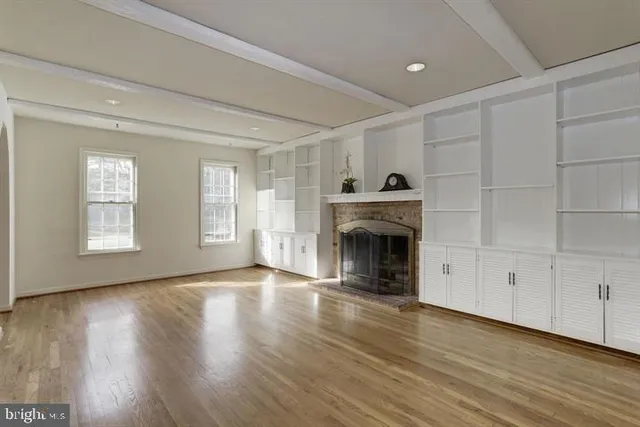 wooden floor fireplace and windows in an empty room