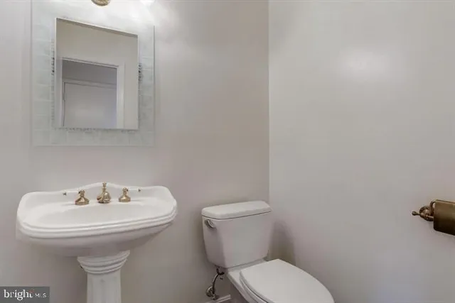 a bathroom with a sink toilet and a mirror