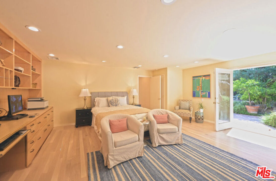 601 Tuallitan Road Los Angeles, CA 90049 - Photo 14 of 23 a bedroom with a bed and wooden floor