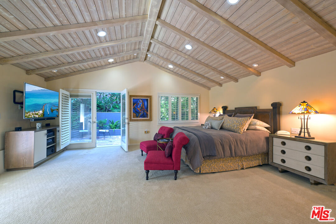 601 Tuallitan Road Los Angeles, CA 90049 - Photo 15 of 23 a spacious bedroom with a bed and a tv with the dresser
