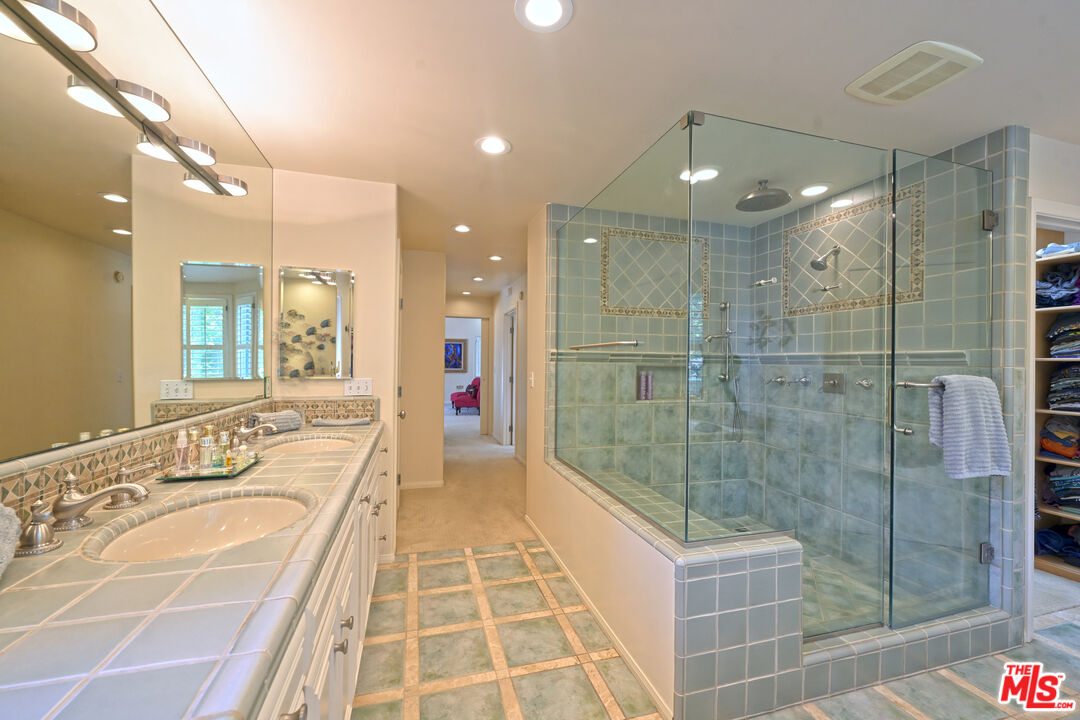 601 Tuallitan Road Los Angeles, CA 90049 - Photo 17 of 23 a bathroom with a double vanity sink and mirror