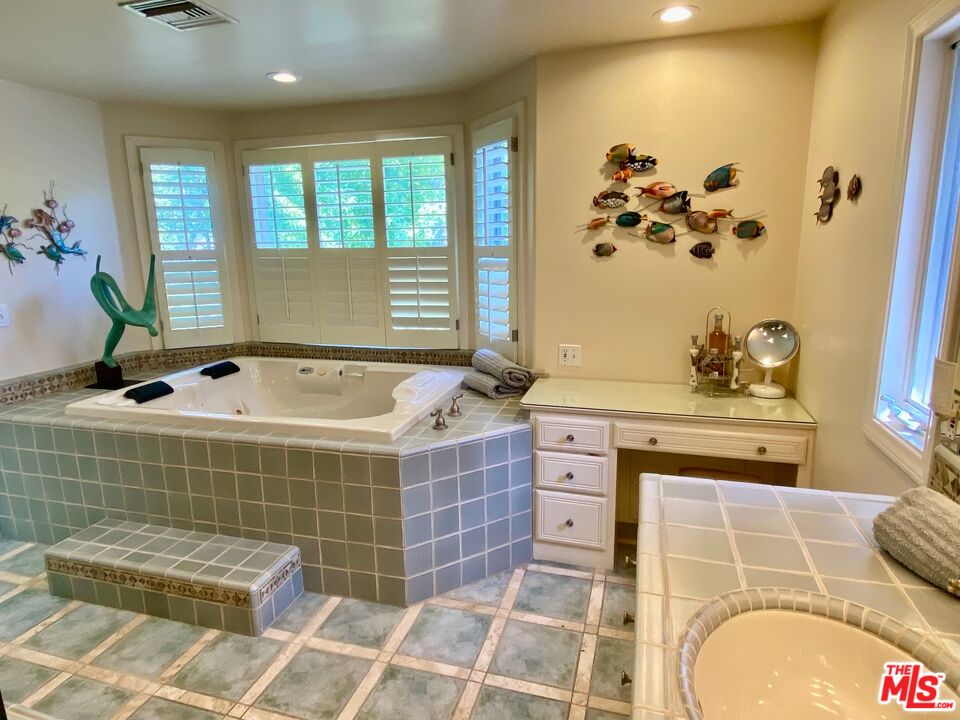 601 Tuallitan Road Los Angeles, CA 90049 - Photo 18 of 23 a bathroom with a tub a sink and a shower