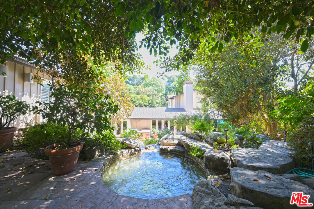 601 Tuallitan Road Los Angeles, CA 90049 - Photo 22 of 23 a view of a house with backyard sitting area and garden