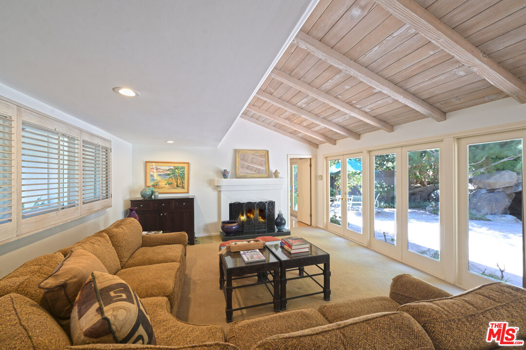 601 Tuallitan Road Los Angeles, CA 90049 - Photo 4 of 23 a living room with furniture a fireplace and a large window