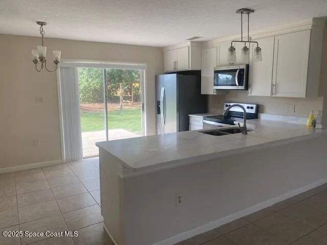 a kitchen with stainless steel appliances granite countertop a sink a microwave a refrigerator and a stove