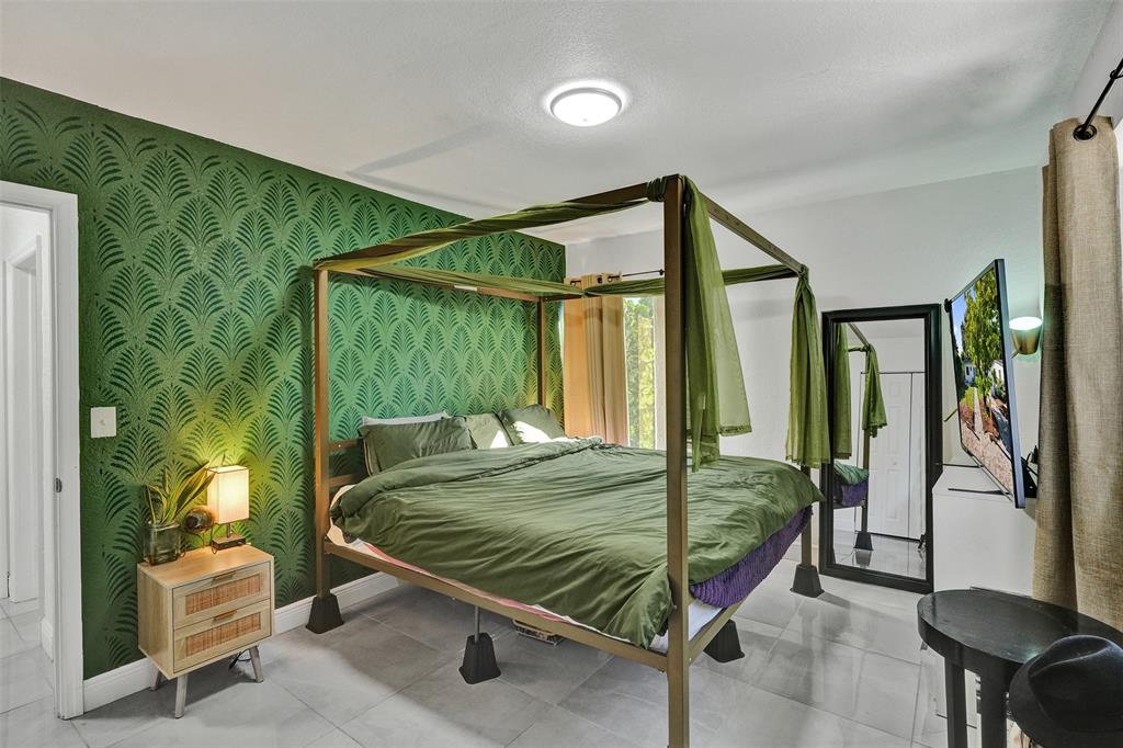 220 Northeast 165th Street Miami, FL 33162 - Photo 12 of 26 a bed sitting in a bedroom next to a window