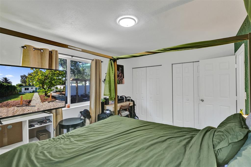 220 Northeast 165th Street Miami, FL 33162 - Photo 14 of 26 a bed room with a bed and a chair