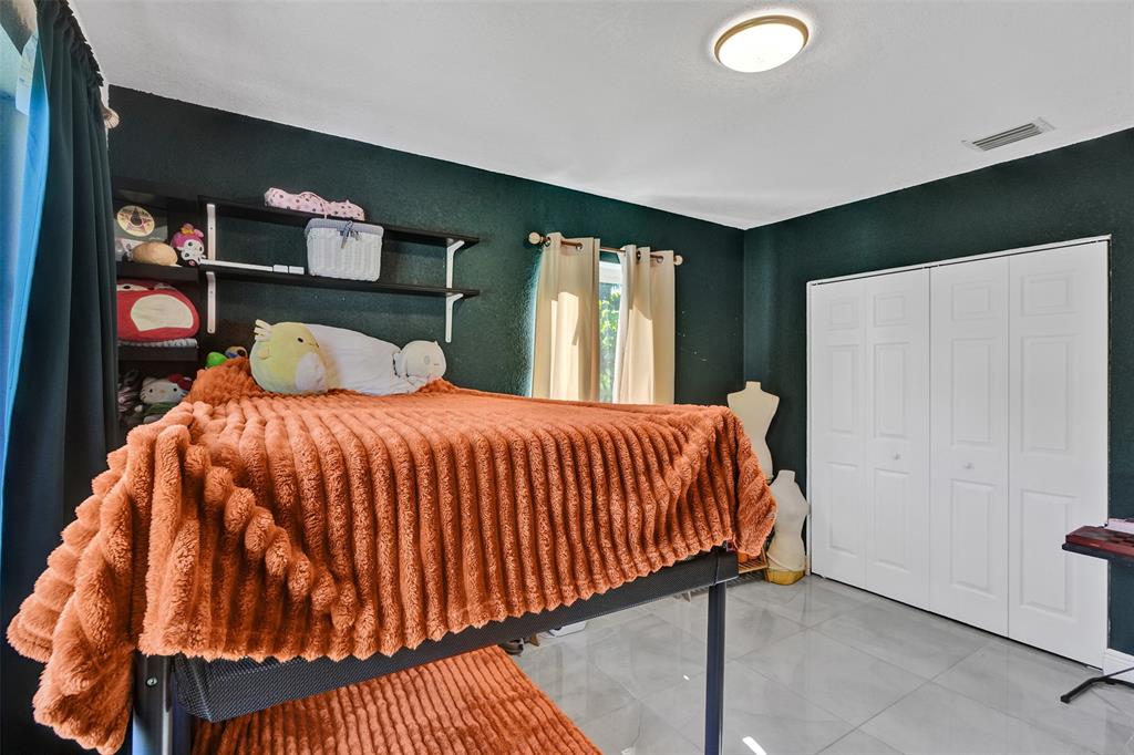 220 Northeast 165th Street Miami, FL 33162 - Photo 16 of 26 a bedroom with a bed and window