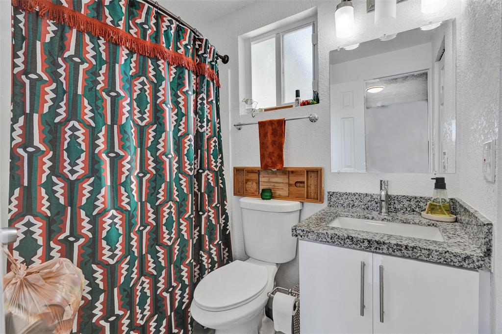 220 Northeast 165th Street Miami, FL 33162 - Photo 19 of 26 a bathroom with a granite countertop sink mirror vanity and toilet