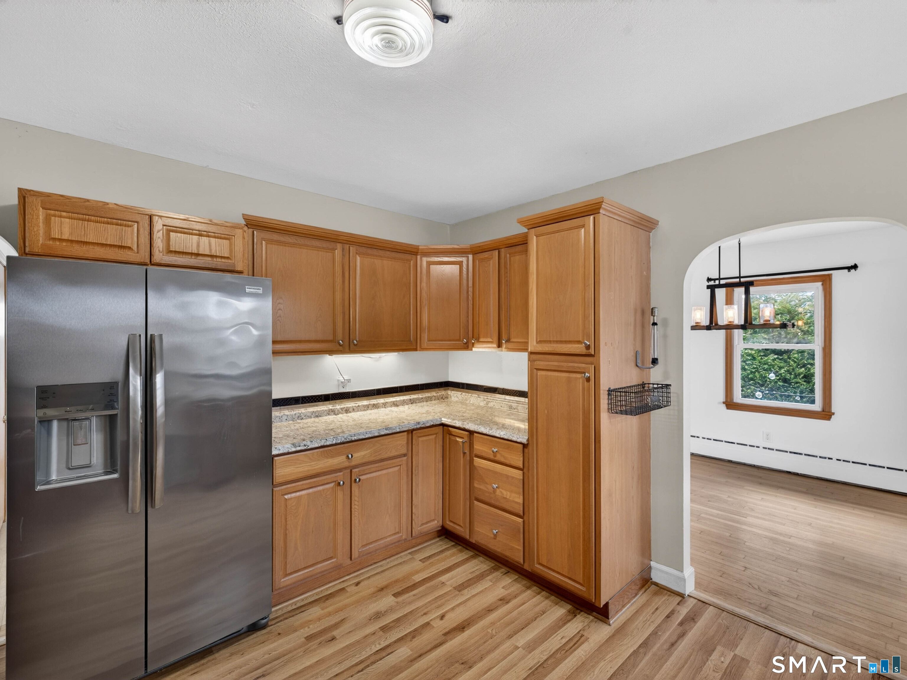 36 Baker Avenue Groton, CT 06340 - Photo 21 of 38 a kitchen with stainless steel appliances granite countertop a refrigerator a sink and white cabinets with wooden floor