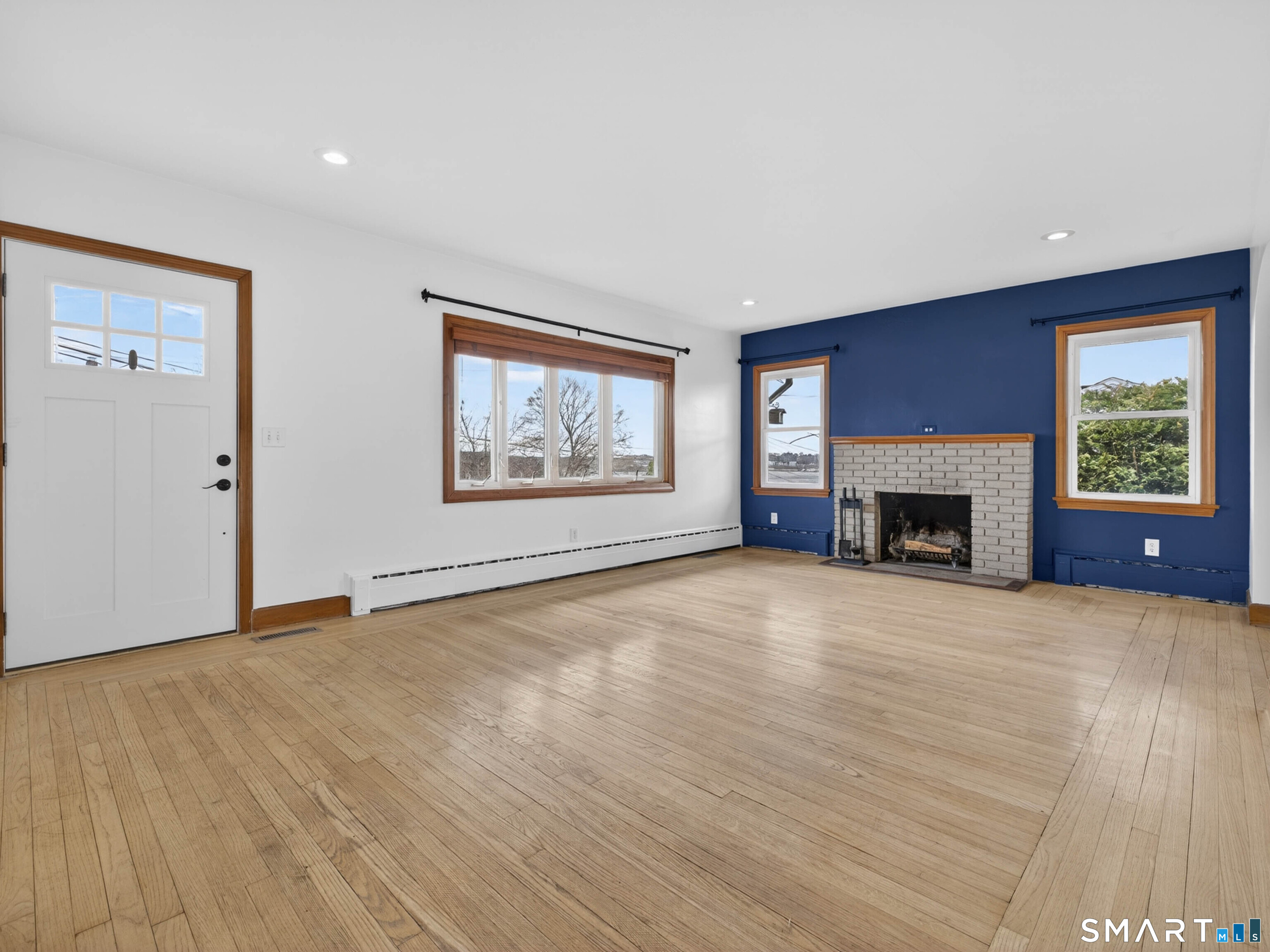 36 Baker Avenue Groton, CT 06340 - Photo 7 of 38 an empty room with windows fireplace and wooden floor