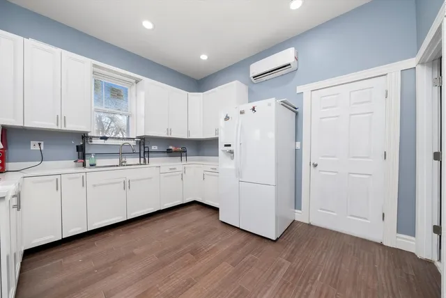a kitchen with white cabinets and white appliances
