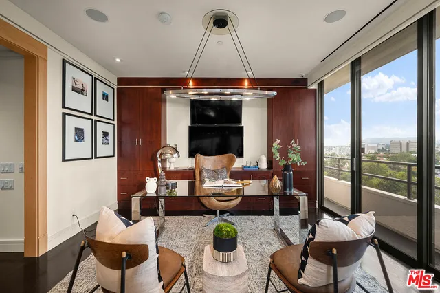 a living room with furniture a chandelier and a floor to ceiling window