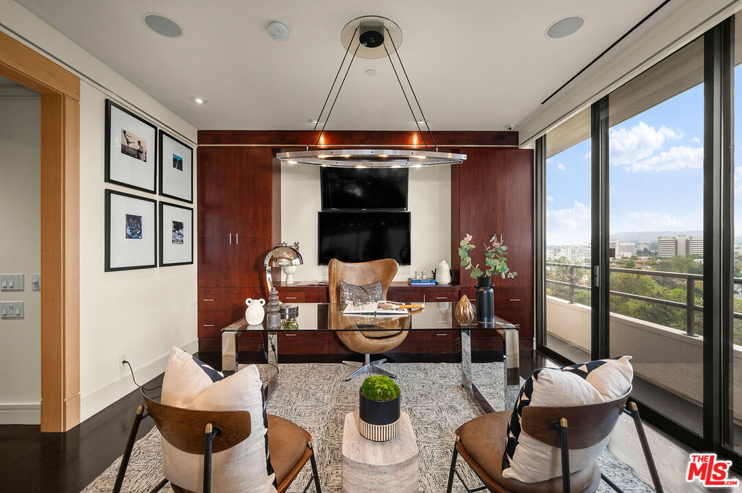 10601 Wilshire Boulevard, Unit 1201 Los Angeles, CA 90024 - Photo 11 of 48 a living room with furniture a chandelier and a floor to ceiling window