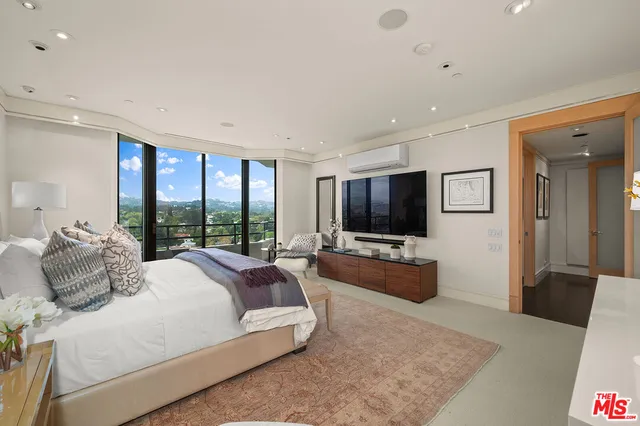 a large bedroom with a bed and flat screen tv
