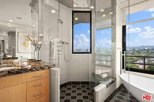 a bathroom with a granite countertop sink a toilet and shower