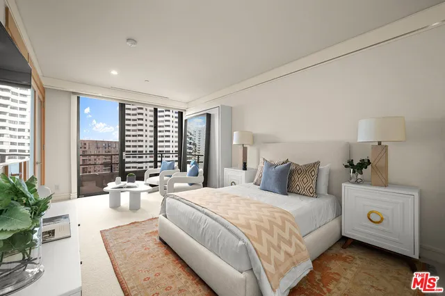 a large bedroom with a large bed and large windows