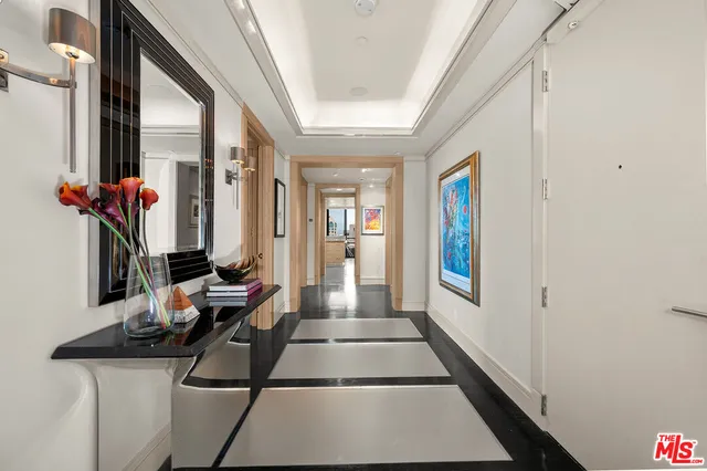 a hallway with beautiful frames and flower vase
