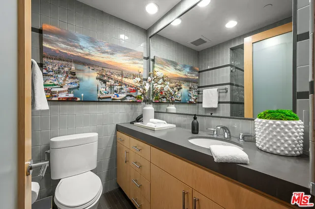 a bathroom with a granite countertop toilet sink and mirror