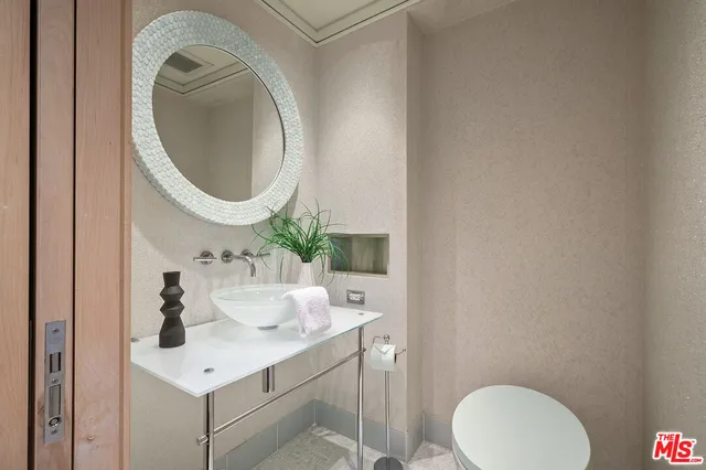 a bathroom with a sink mirror and toilet