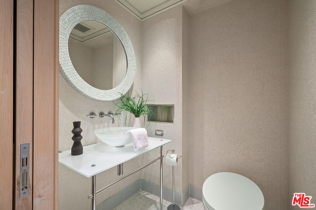 10601 Wilshire Boulevard, Unit 1201 Los Angeles, CA 90024 - Photo 34 of 48 a bathroom with a sink mirror and toilet