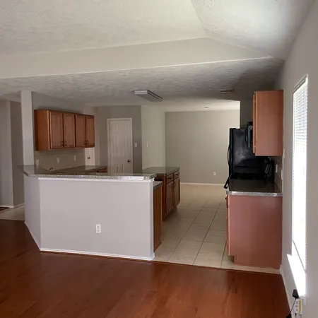 a living room with stainless steel appliances kitchen island granite countertop a refrigerator a stove top oven a sink and dishwasher