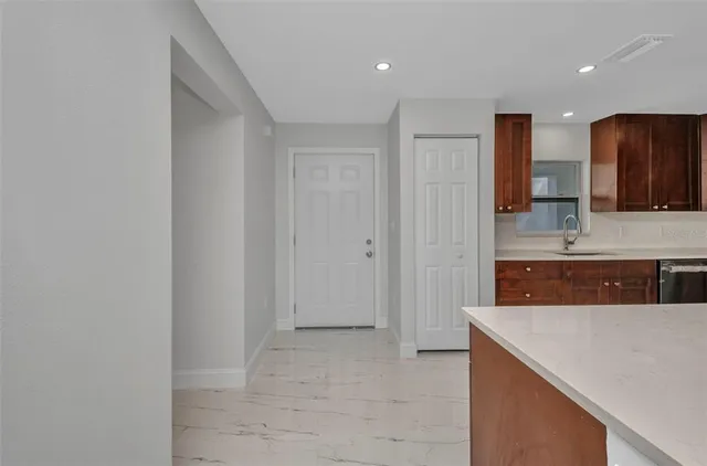 a large kitchen with stainless steel appliances granite countertop a refrigerator a stove a oven and a sink