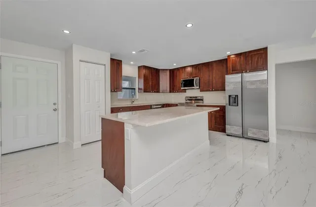 a kitchen with stainless steel appliances granite countertop wooden cabinets a stove top oven a sink and dishwasher