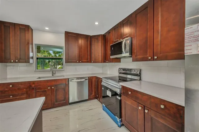 a kitchen with a sink appliances and cabinets