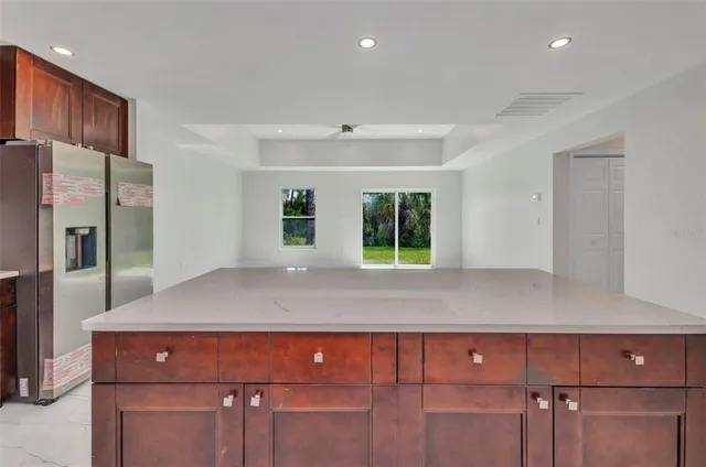 a kitchen with stainless steel appliances a refrigerator a stove a sink a oven with wooden floors and a window