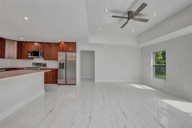 a view of kitchen with refrigerator and a stove top oven