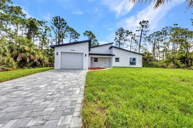 a white house that has a tree in front of it