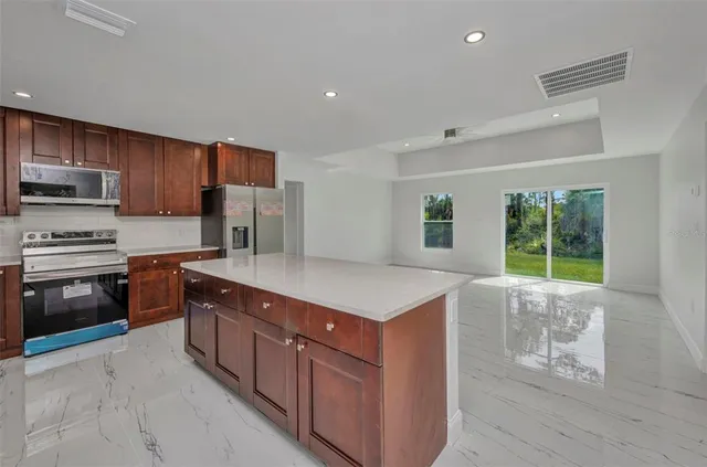 a kitchen with stainless steel appliances granite countertop a washer and a refrigerator