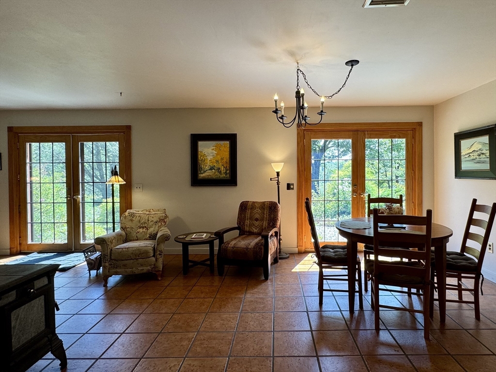 1450 W Road Ashfield, MA 01330 - Photo 10 of 36 a living room with furniture a large window and a flat screen tv