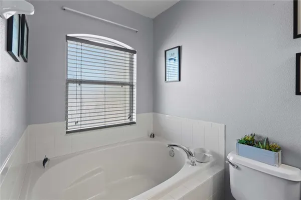 a bathroom with a sink mirror and tub