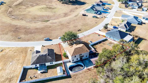 an aerial view of a house with a yard and trees