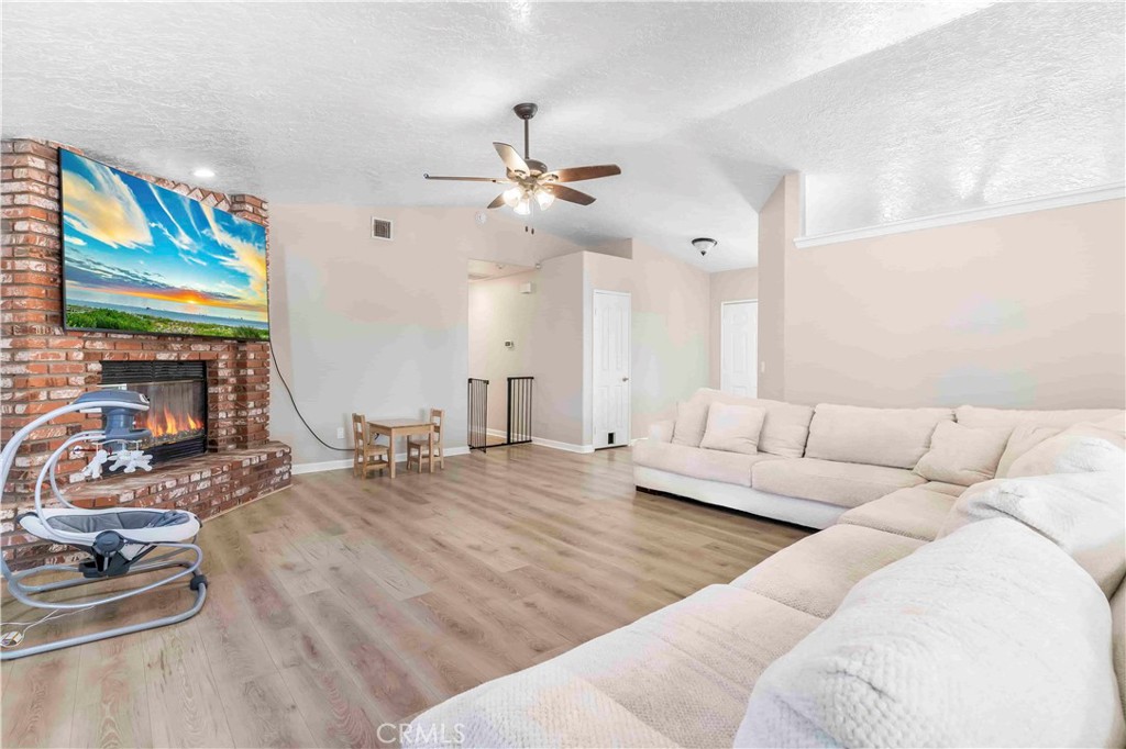 15189 Tonikan Road Apple Valley, CA 92307 - Photo 20 of 39 a living room with furniture ceiling fan and a wooden floor